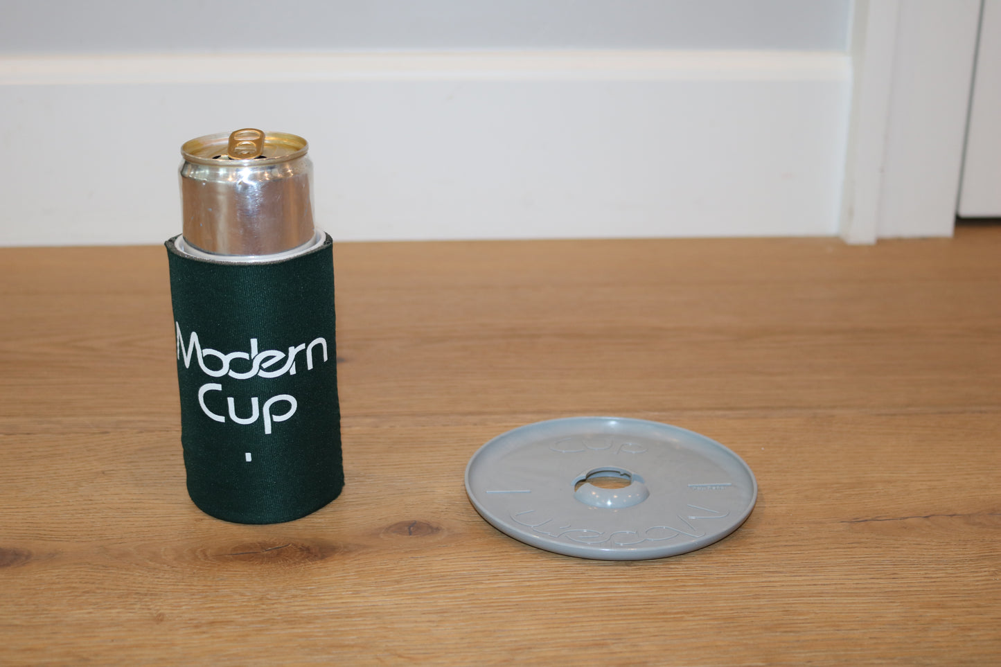 A can of soda inside a dark green "Modern Cup"