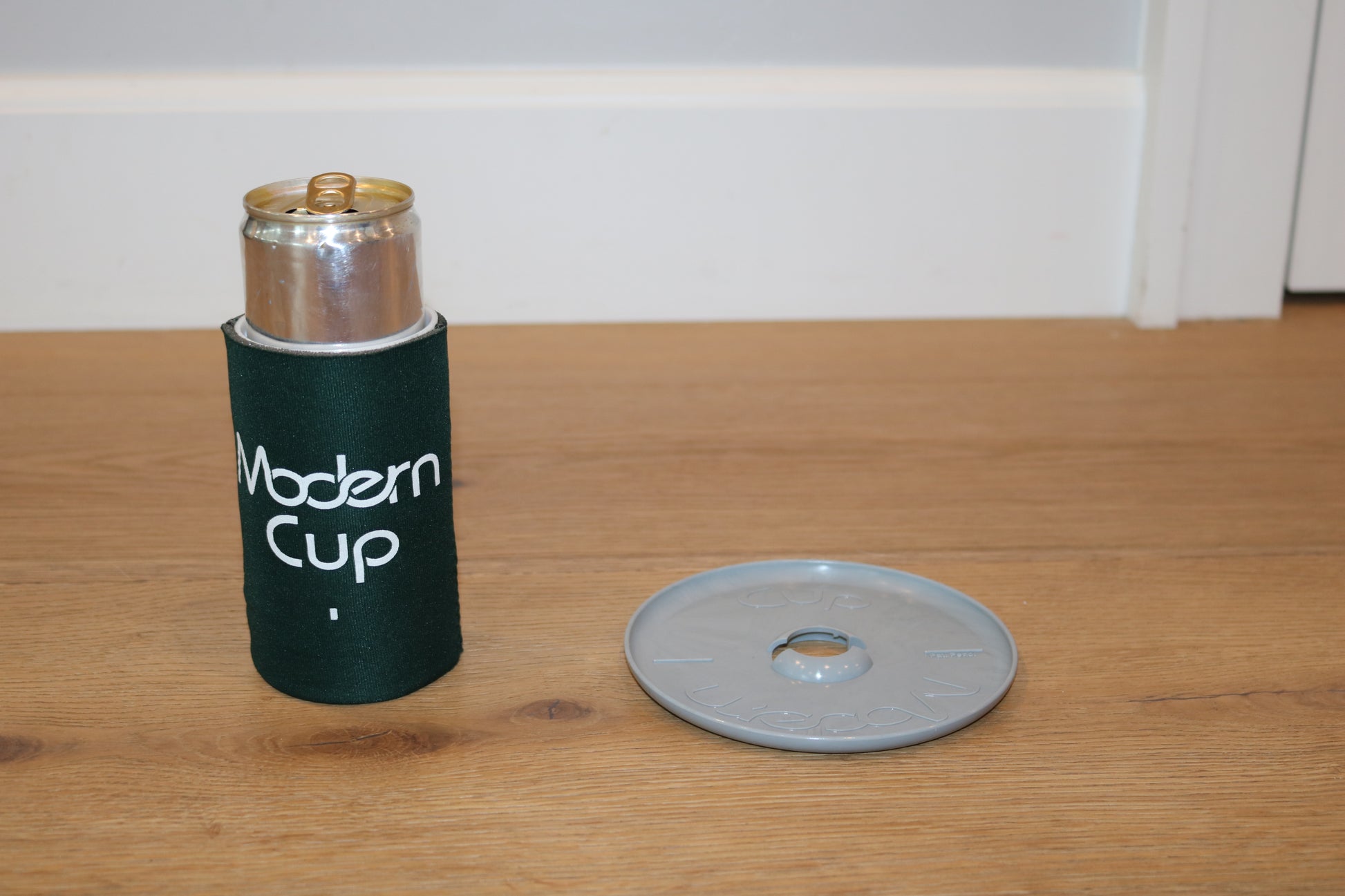 A can of soda inside a dark green "Modern Cup"