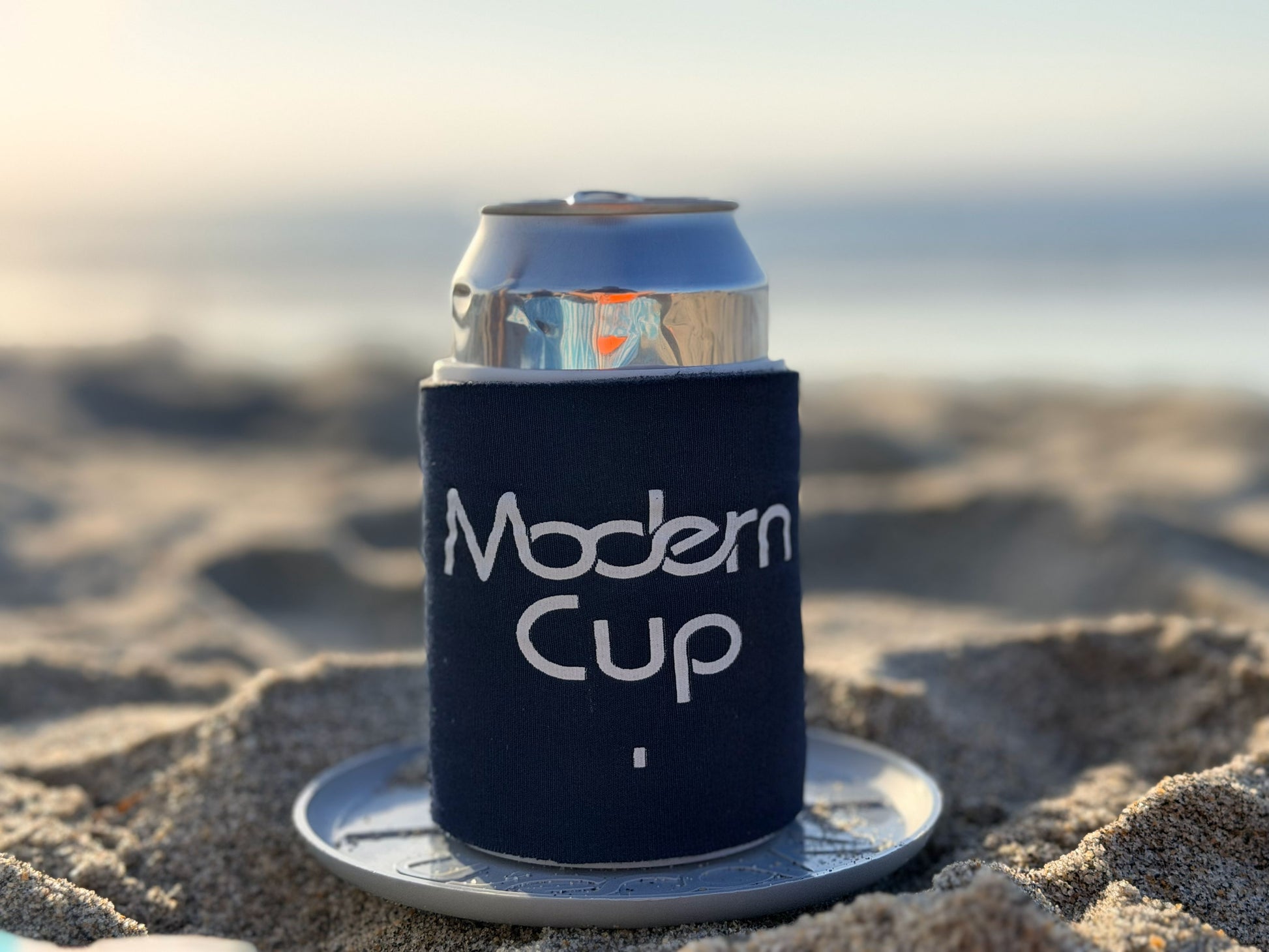 A close-up of a can inside a dark blue "Modern Cup" 